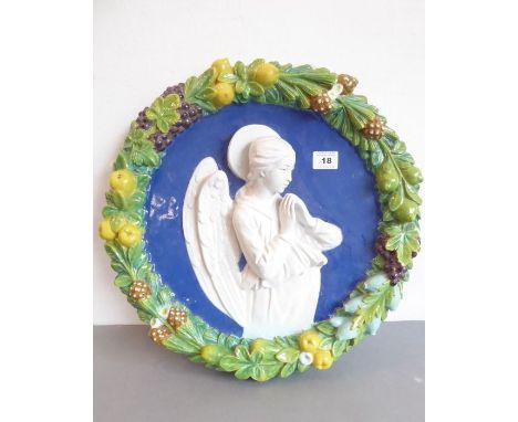 A late 19th / early 20th century polychrome decorated circular pottery wall plaque in the style of Luca della Robbia; the cen