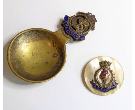 Naval interest; an early 20th century brass caddy spoon (once silver plated), the finial mounted with the enamelled badge of 