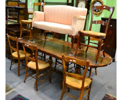 A continental walnut extending dining table with two rounded leaves and two additional leaves, raised on bobbin turned legs a