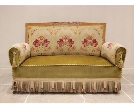 A Victorian sofa, the upholstered floral tapestry back rest within a carved walnut frame, extending to the two conforming dro