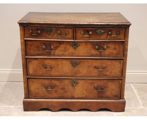 A George I and later walnut chest of drawers, the rectangular moulded top over two short and three long feather banded and gr