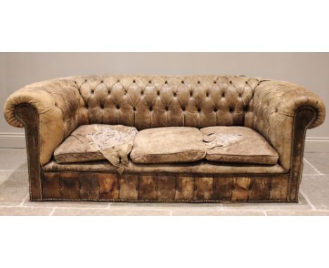 A large leather upholstered Chesterfield sofa, late 19th/early 20th century, the curved button back with three pad seats, in 