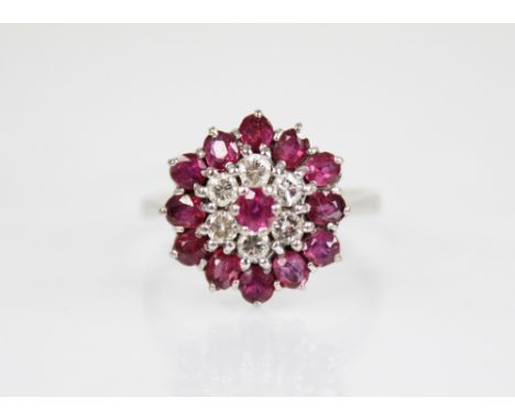 A diamond and ruby 18ct white gold cluster ring, the tiered cluster comprising a central round mixed cut ruby surrounded of s