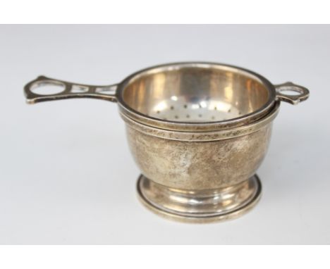 A silver tea strainer and stand, G W Lewis & Co Birmingham 1943, with openwork handle, 3.5cm high, weight 53.9gmsCR; Light de