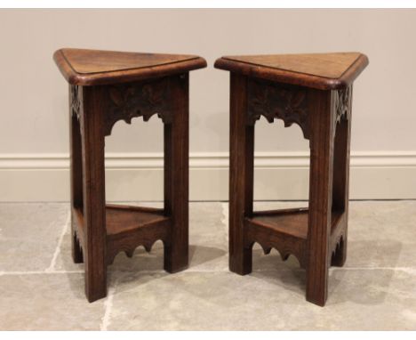 A pair of 17th century style oak lamp tables, late 20th century, each with a hinged triangular top above a frieze carved with