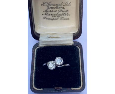 An early 20th century diamond 'toi-et-moi' ring, comprising two cushion cut diamonds, one measuring 5.01mm x 4.75mm x 3.23mm,