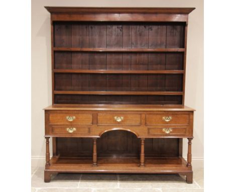 A George III and later oak Welsh dresser, the enclosed plate rack with a moulded cornice above three shelves, upon the pot bo