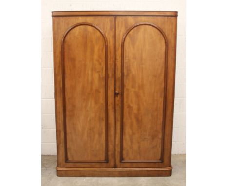 A large Victorian mahogany wardrobe, the rectangular wardrobe designed with two cupboard doors applied with arch moulding, op