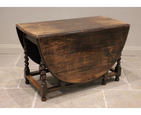 A 17th century style oak drop leaf dining table, late 19th/early 20th century, the moulded oval top raised upon barley twist 