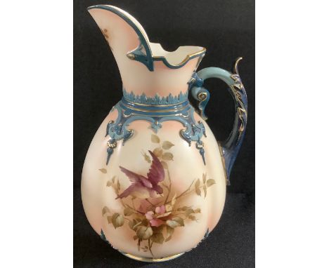 A Hadley's Worcester Faience lobed ovoid jug, painted in sepia tones with a bird perched amongst blossom, scroll handle with 