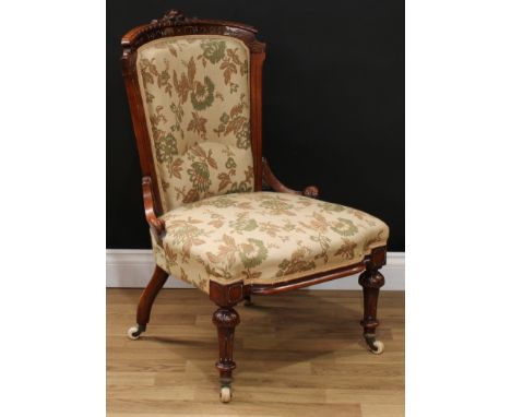 A Victorian walnut and mahogany drawing room chair, curved cresting rail carved with stylised leaves, stuffed-over upholstery