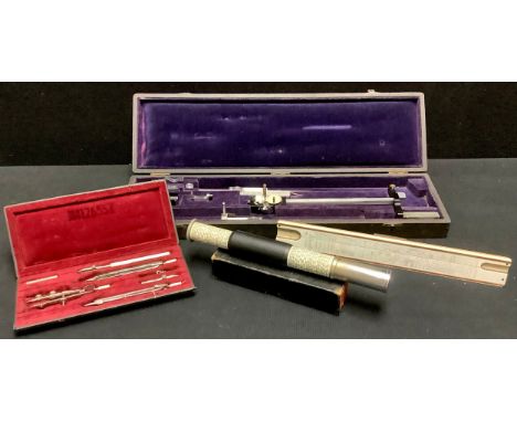 An engineer's or draughtsman's measuring set, cased; a similar compass set, cased; a slide rule, another cylindrical (4) 