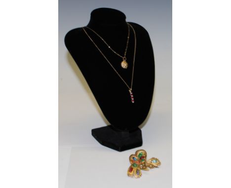A 9ct gold diamond chip and ruby pendant on a 9ct gold necklace chain, marked 375, a 9ct gold sunburst pendant and chain mark