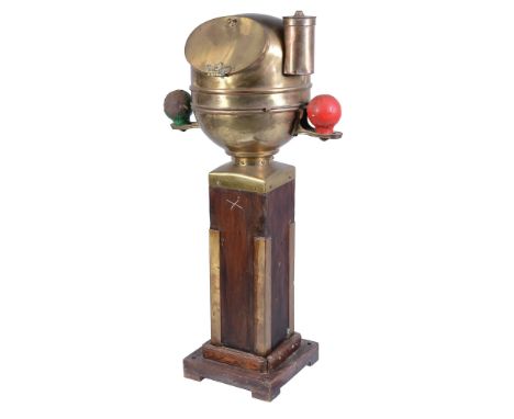  A ships stern binnacle,   with polished brass hood enclosing the binnacle compass flanked by red and green navigation balls 