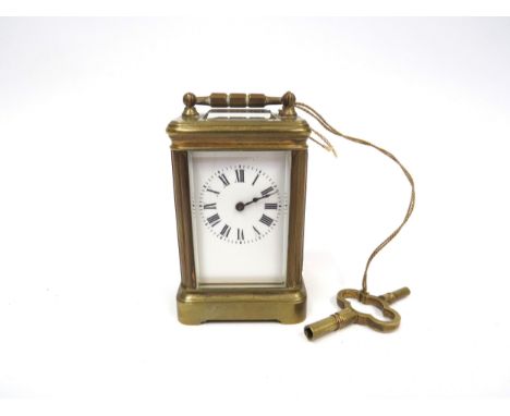 A late 19th Century miniature brass cased carriage timepiece, with white Roman dial and bevel edge glass to all sides, silver