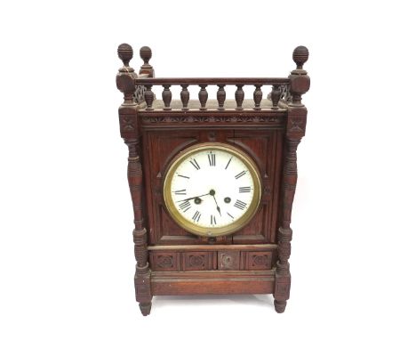 A oak cased bracket clock with enamel Roman dial, flanked by turned columns and galleried top, the French movement striking o