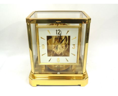 JAEGER-LECOULTRE: A gilt brass cased Jaeger-LeCoultre Atmos clock, calibre 528-8, white square chapter ring with gilt Arabic 
