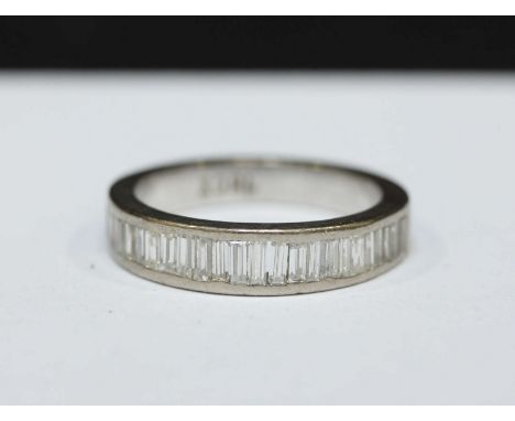 An 18ct white gold and diamond half eternity ring, channel set with thirteen slightly graduated baguette-cut diamonds, the di