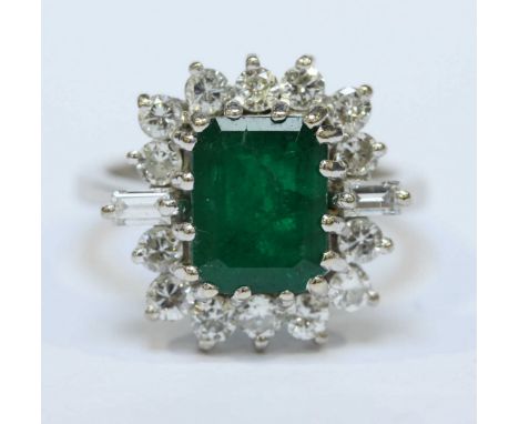 An 18ct white gold, emerald and diamond dress ring, centrally claw-set emerald cut measuring 8.89mm x 7.17mm, estimated 1.70 