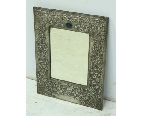 An Art Nouveau pewter wall mirror, the frame elaborately embossed with flowers, leaves and trailing branches, the top inset w