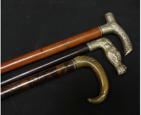 A Chinese silver dragons head handled walking stick, together with another Chinese white metal topped walking stick and a hor