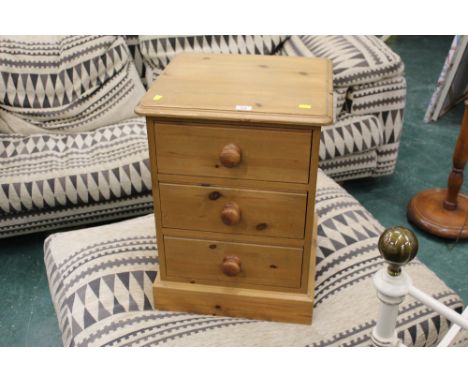 A pine three drawer bedside chest 