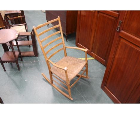A 19th century oak rush seat ladder back rocking chair