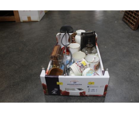 A box of commemorative mugs, Wedgwood blue Jasperware ashtray, vintage camera, oil lamp etc