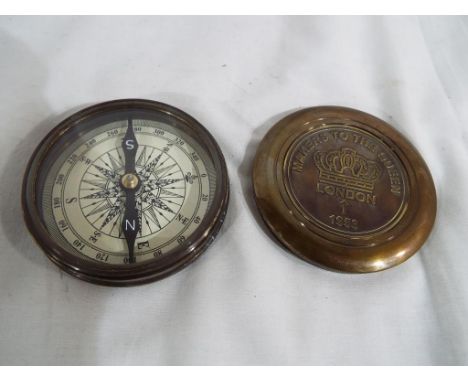 A brass compass with screw release lid, Est £20 - £40