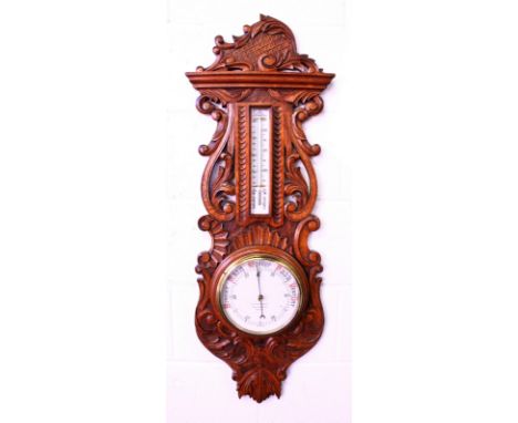 A BAROMETER AND THERMOMETER in a carved oak case by G. C. BATEMAN, READING. 3ft 5ins long.