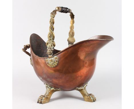 A GOOD COPPER AND BRASS HELMET SHAPED COAL SCUTTLE on three iron claw feet.