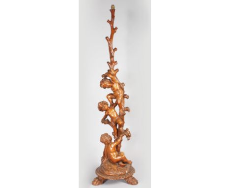 A SUPERB 18TH-19TH CENTURY ITALIAN CARVED WALNUT STANDARD LAMP with three cupids climbing a tree, on a circular base with thr