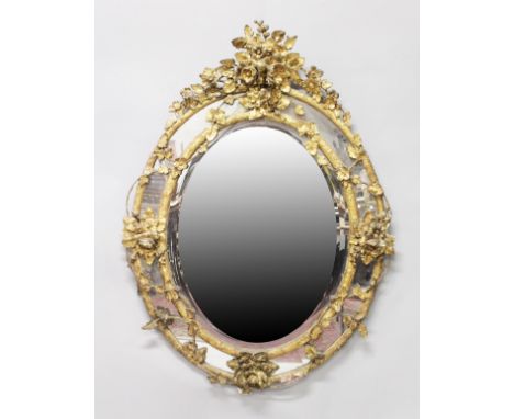 A GOOD LARGE 19TH CENTURY FRENCH OVAL GILTWOOD MIRROR, the frame decorated with leaves and flowers. 5ft 0ins high x 3ft 8ins 