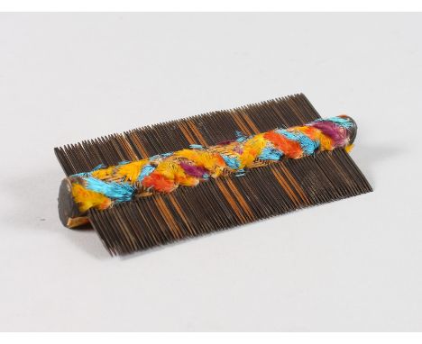 A RARE AMERICAN INDIAN COMB decorated with feathers. 4.5ins long.