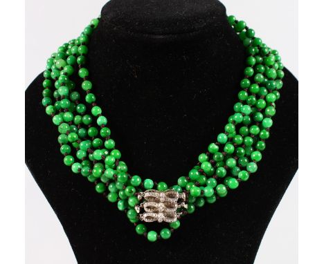 A GOOD TRIPLE ROW JADE NECKLACE with diamond clasp.