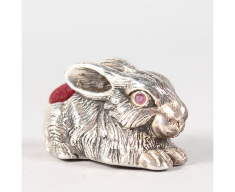 A LARGE SILVER RABBIT PIN CUSHION with ruby eyes.