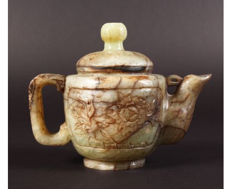 AN EARLY 20TH CENTURY CHINESE BOWENITE TEAPOT & COVER, the sides carved with panels of extended foliage, the stone of predomi