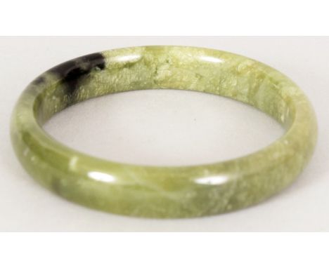 A CHINESE PALE SPINACH GREEN JADE BANGLE, 2.8in diameter, the inner rim 2.25in diameter.
