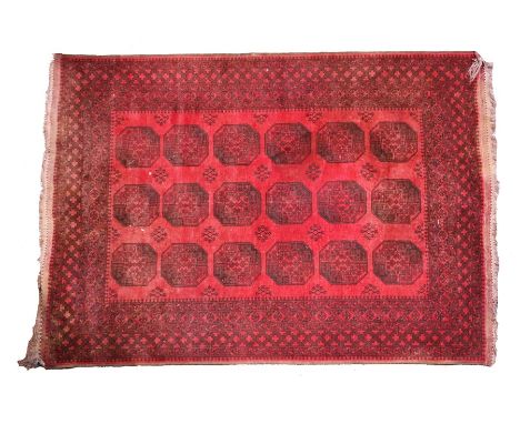 Afghanistan carpet, in red with three rows of geometric panels, 274cm x 200cm