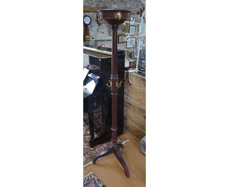 A late 19th/20th C mahogany tripod cloak stand, fitted with numerous brass hangers, the circular top part revolving