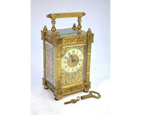 A 19th century Gothic style gilt cased carriage clock, the white ceramic dial within an engraved mask, 15 cm hl/h glass panel