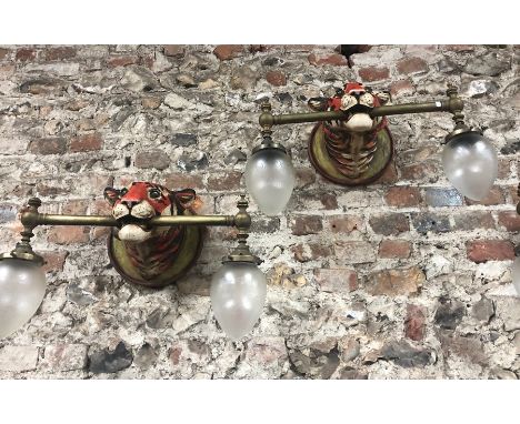 SALEROOM AMENDMENT - An unusual pair of (NOT FOUR) 'Tiger' mask wall lights, the polychromed composite heads mounted with bra
