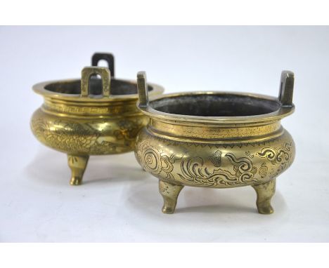 Two Chinese gilt incense burners; each one of typical tripod and circular form with pierced handles; one decorated on the ext