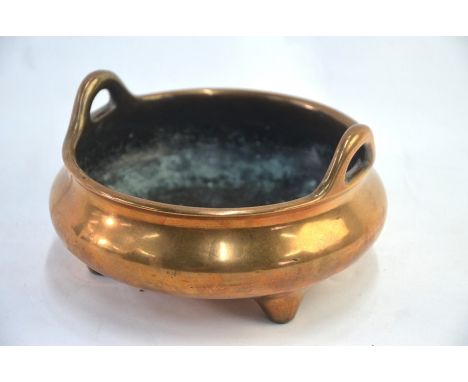 A Chinese metal incense burner of typical circular and tripod form with pierced handles; the base with four-character mark, 1