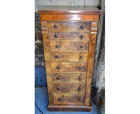 A Victorian walnut Wellington chest of eight graduated drawers with turned pulls, raised on a plinth base, the top drawer sta