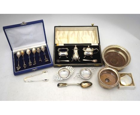 A silver bottle coaster, London 1969 to/w two tea strainers, Birmingham 1912 &amp; Sheffield 1939, a cased three piece condim