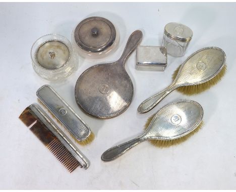 An engine-turned silver five-piece brush set, to/w two silver-topped powder bowls and two other toilet jars (9)