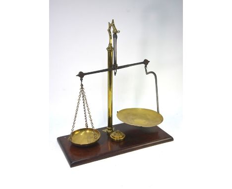A set of brass pillar balance scales on a mahogany base, to/w a set of seven graduated weights (two associated) and a brass b