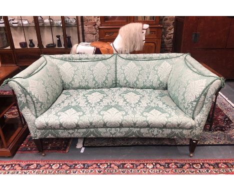 A late 19th/20th century two seat sofa, the green leaf design satin upholstery with contrasting rope edging, raised on square