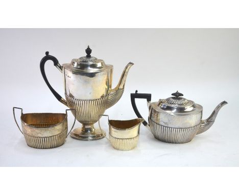 A matched four piece silver tea/coffee service of oval half-reeded form, the coffee pot on stemmed foot, various makers 1895-